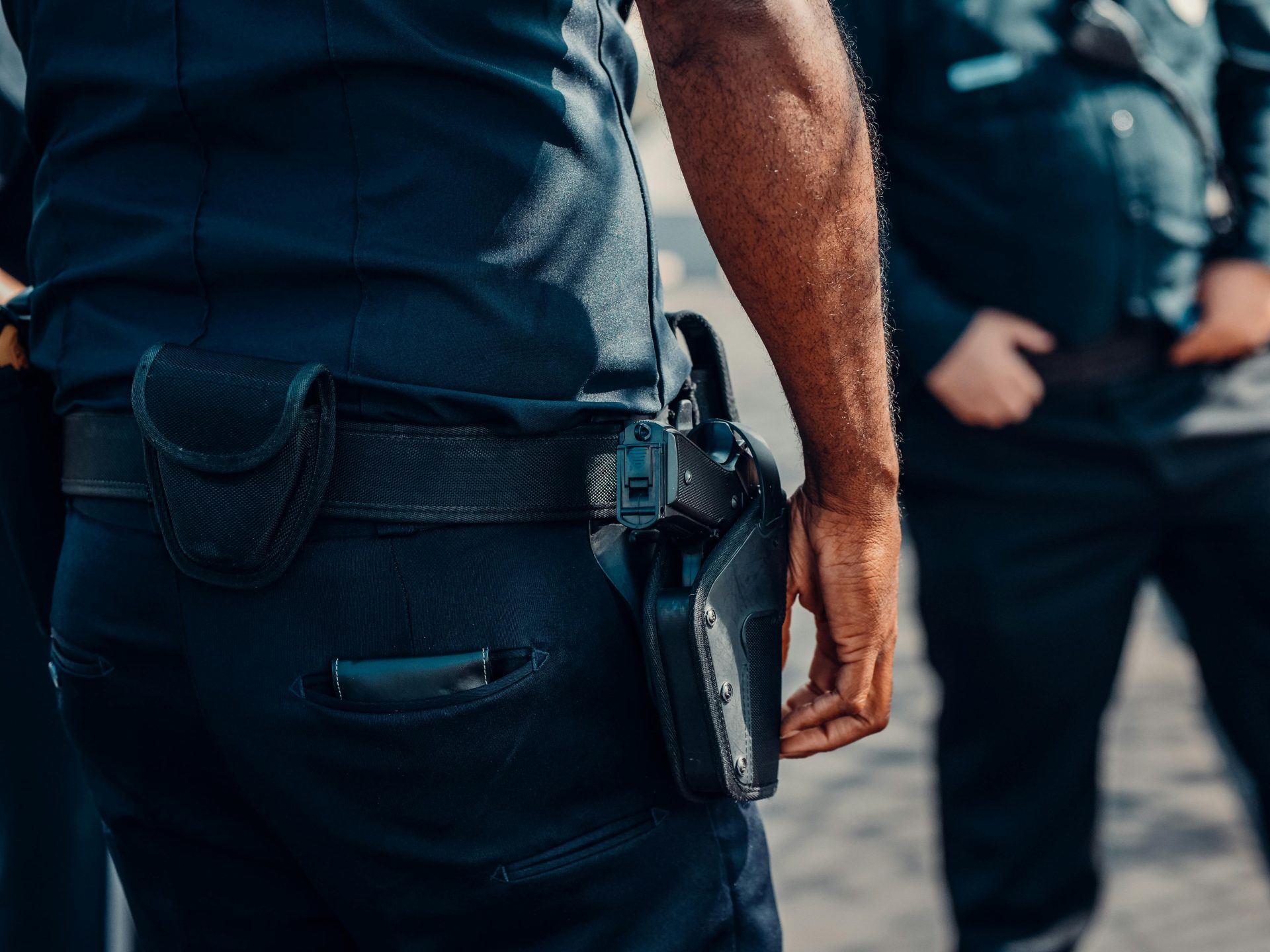 Primer plano del arma de fuego de un agente de policía, enfundada de forma segura en la cintura, lo que transmite profesionalidad y preparación.