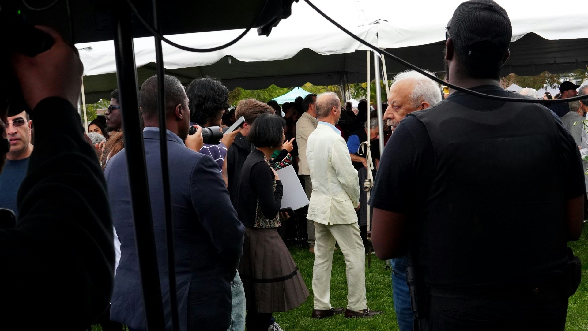 Un guardia de seguridad vigila una reunión bajo una carpa.